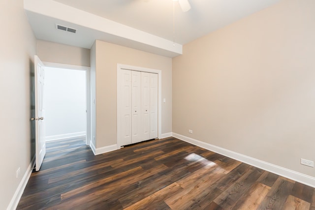 unfurnished bedroom featuring ceiling fan, dark hardwood / wood-style floors, and a closet