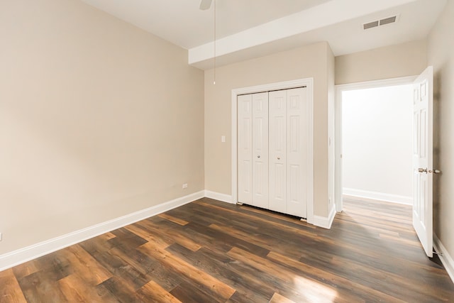 unfurnished bedroom featuring a closet, ceiling fan, and dark wood-type flooring