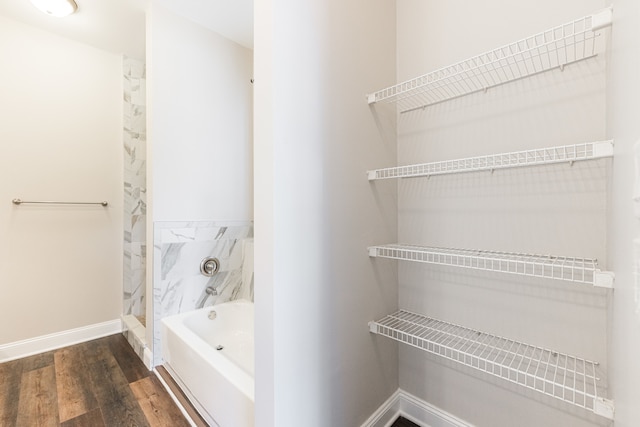 bathroom featuring wood-type flooring and a tub