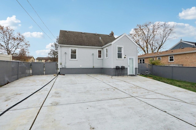 8122 W Oak Ave, Niles, IL 60714 - back of house featuring a chimney, a gate, a patio area, and driveway