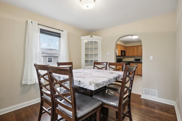 8122 W Oak Ave, Niles, IL 60714 - dining space with arched walkways, baseboards, and wood finished floors