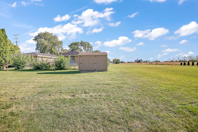 view of yard featuring a rural view and a storage unit