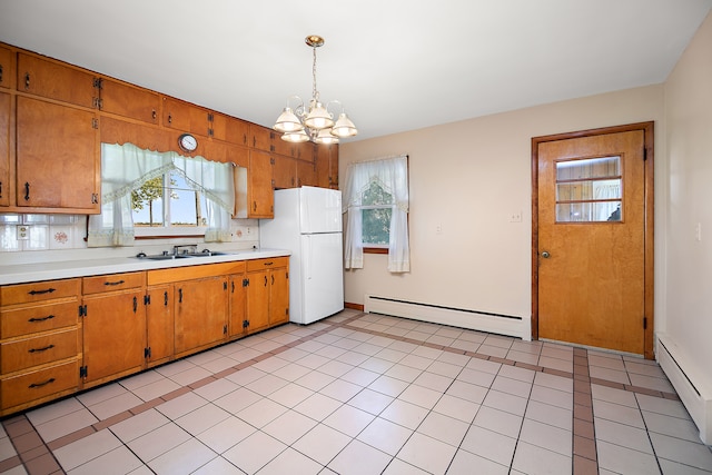 kitchen with a baseboard radiator, a chandelier, white refrigerator, and hanging light fixtures