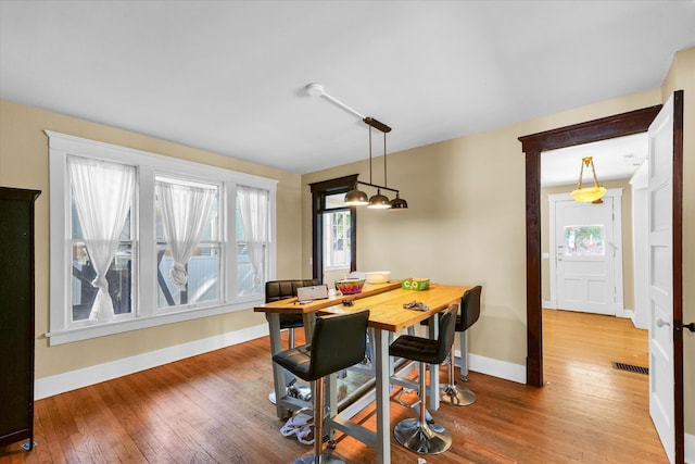 dining space featuring wood-type flooring and a healthy amount of sunlight