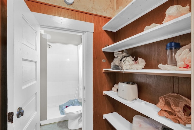 interior space featuring toilet, wood walls, and a shower with curtain