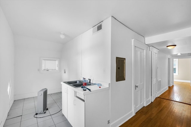 kitchen with a healthy amount of sunlight, light hardwood / wood-style flooring, white cabinets, and radiator