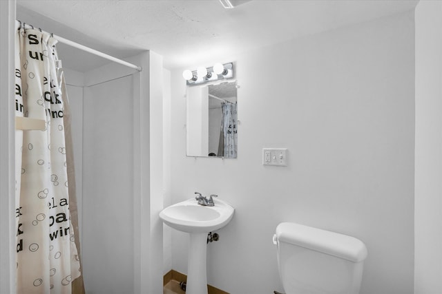 bathroom featuring toilet and a shower with shower curtain