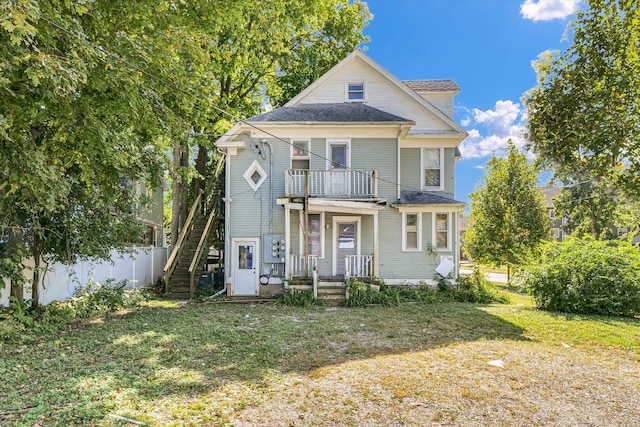 view of front of home with a front yard and a balcony