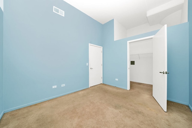 unfurnished bedroom featuring light colored carpet and a closet