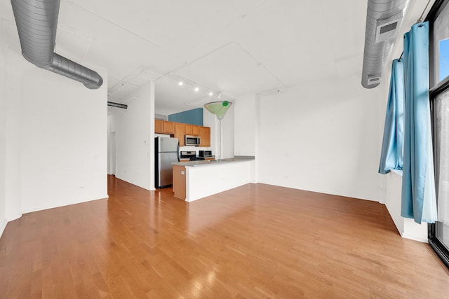 unfurnished living room with sink and light hardwood / wood-style flooring