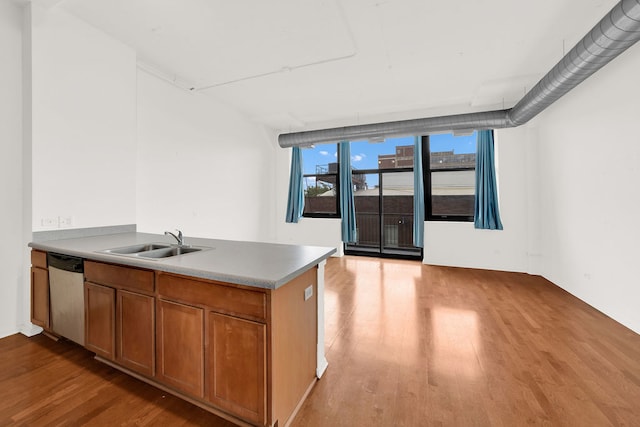 kitchen with light wood-type flooring, dishwasher, and sink