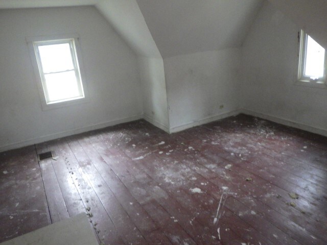 additional living space featuring vaulted ceiling and dark hardwood / wood-style floors