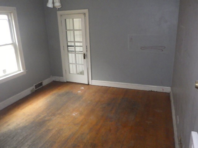 unfurnished room with hardwood / wood-style flooring and plenty of natural light