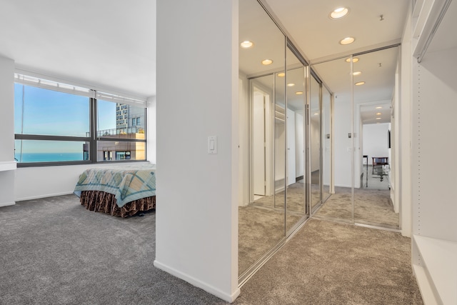 hall with carpet floors and a water view