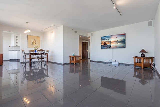 dining room featuring radiator, tile patterned flooring, and track lighting