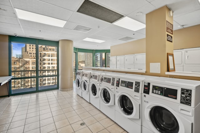 laundry area featuring stacked washer and clothes dryer, light tile patterned flooring, a healthy amount of sunlight, and washing machine and dryer