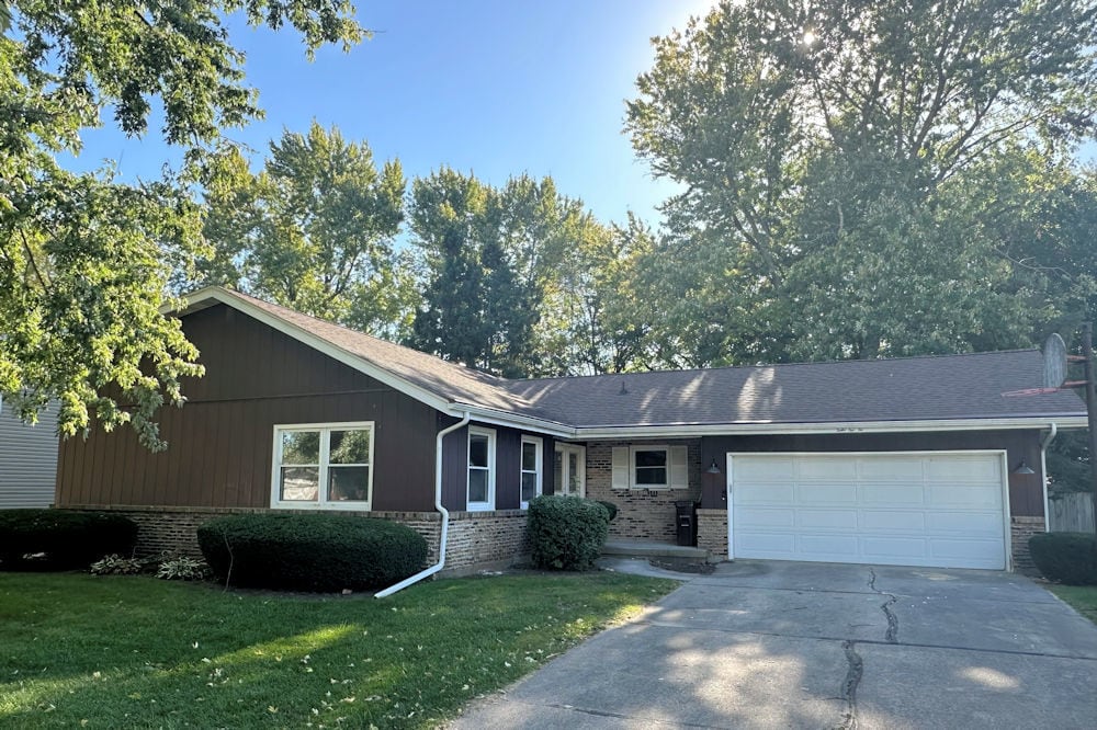 single story home with a garage and a front yard