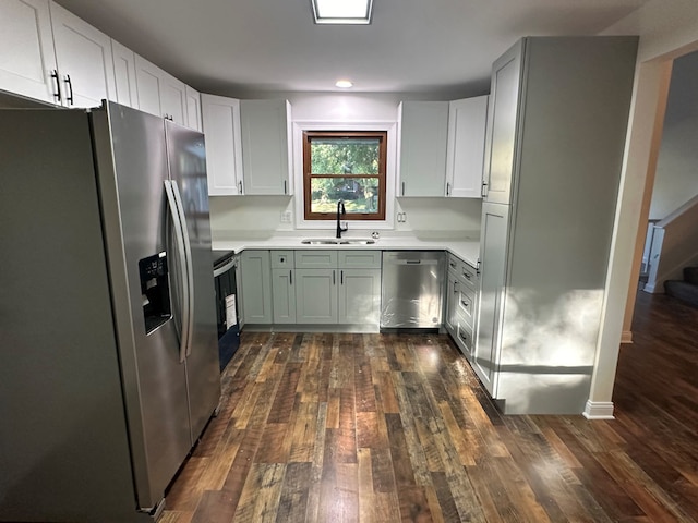 kitchen featuring white cabinets, appliances with stainless steel finishes, dark hardwood / wood-style floors, and sink