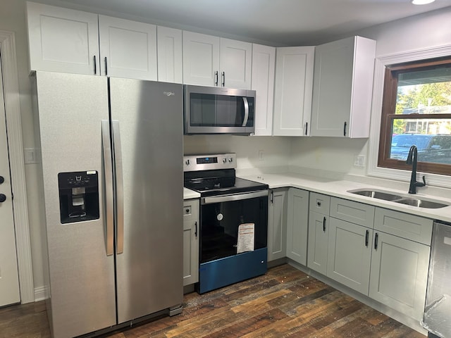 kitchen with white cabinets, appliances with stainless steel finishes, dark wood-type flooring, and sink