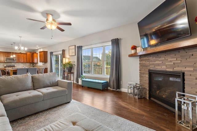 living room featuring ceiling fan with notable chandelier and dark hardwood / wood-style floors