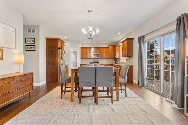 dining area featuring a notable chandelier, light hardwood / wood-style floors, and sink