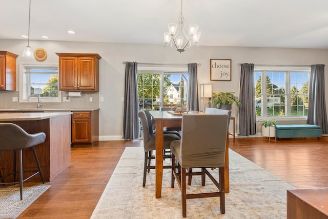 dining area featuring light hardwood / wood-style floors, an inviting chandelier, and a wealth of natural light