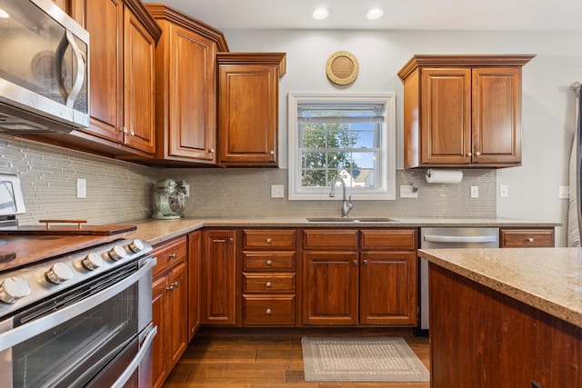 kitchen featuring decorative backsplash, stainless steel appliances, dark wood-type flooring, and sink