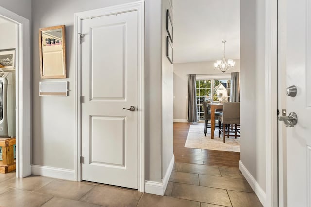 hall with wood-type flooring and a notable chandelier