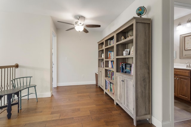 living area featuring ceiling fan, hardwood / wood-style flooring, and sink