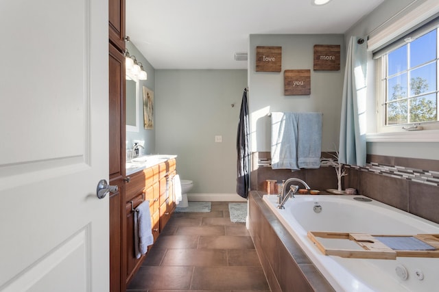 bathroom featuring vanity, tiled bath, toilet, and tile patterned floors