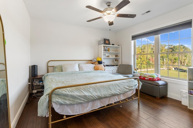 bedroom with multiple windows, dark hardwood / wood-style floors, and ceiling fan