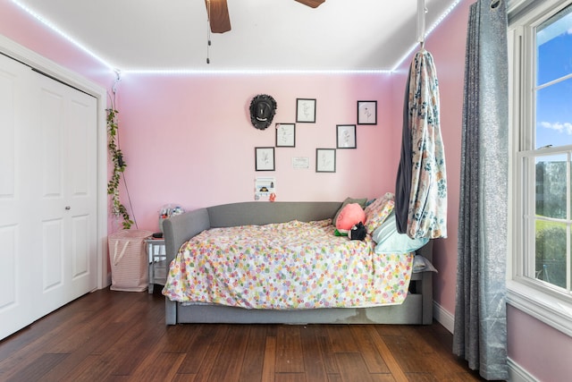 bedroom with a closet, dark hardwood / wood-style floors, and ceiling fan