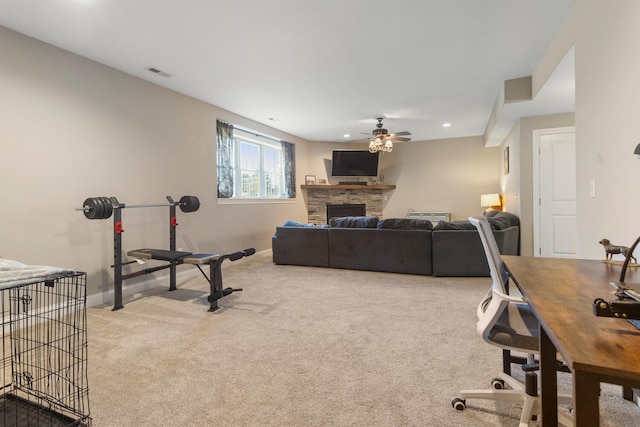 living room with ceiling fan, carpet floors, and a fireplace