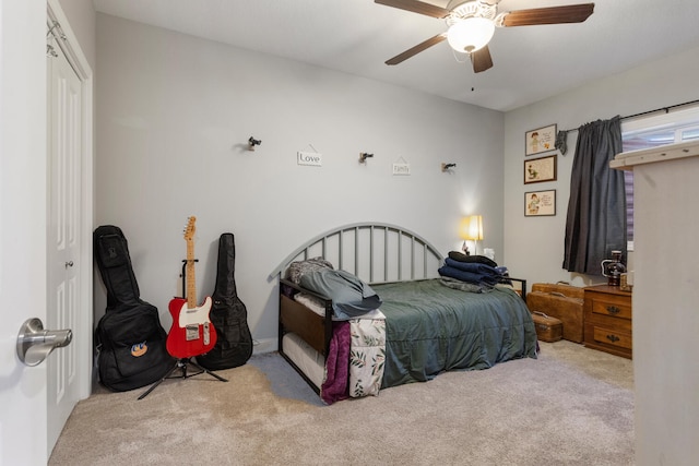 carpeted bedroom featuring ceiling fan and a closet