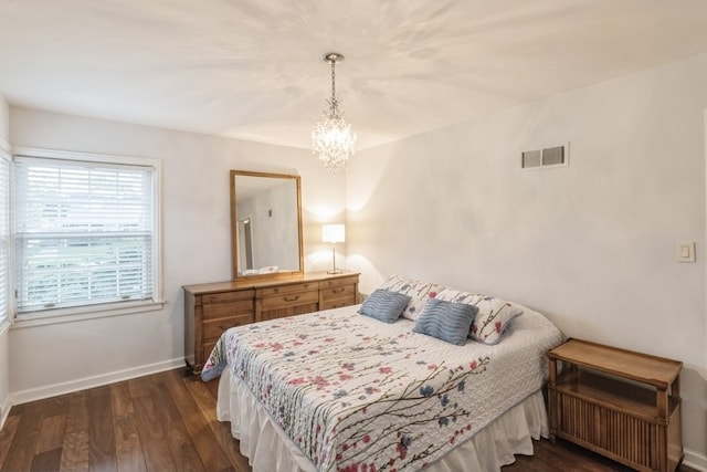 bedroom with a chandelier and dark hardwood / wood-style flooring