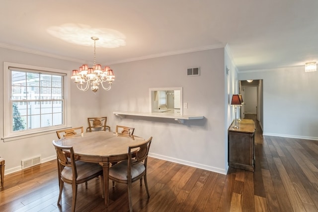 dining room with a chandelier, dark wood-type flooring, and crown molding