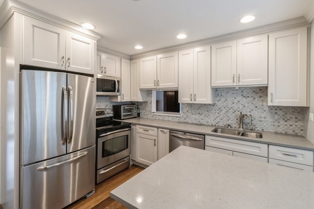 kitchen featuring white cabinetry, dark wood-type flooring, light stone counters, stainless steel appliances, and sink