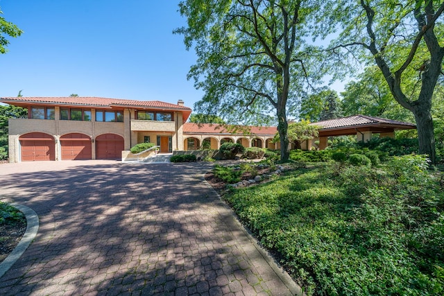 600 Mallard Ln, Oak Brook, IL 60523 - mediterranean / spanish-style house featuring a tile roof, decorative driveway, and a chimney