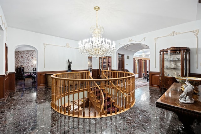 corridor featuring wooden walls and an inviting chandelier