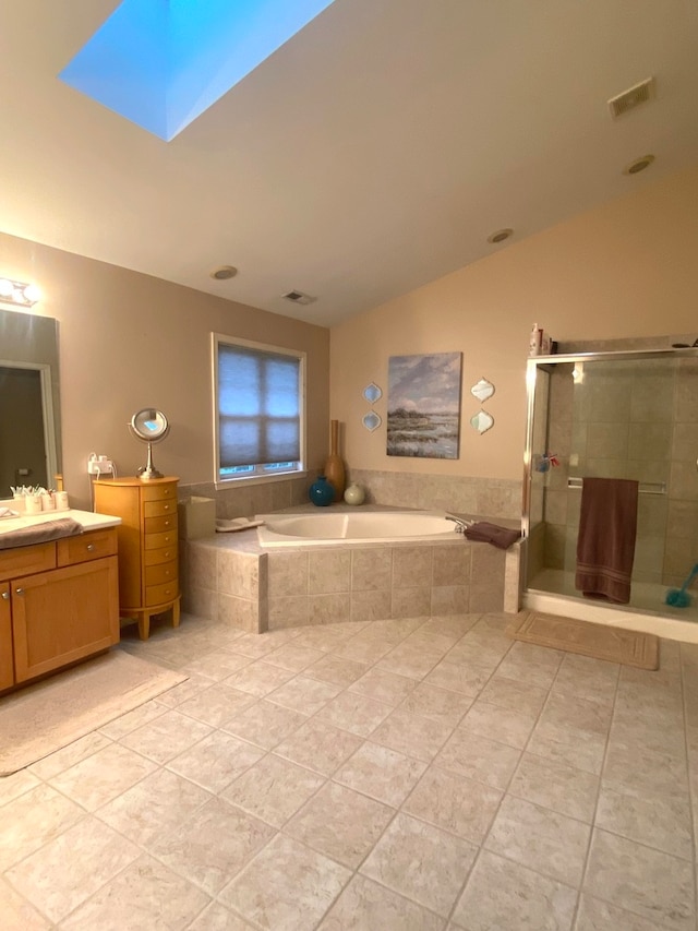 bathroom with lofted ceiling with skylight, vanity, tile patterned flooring, and separate shower and tub