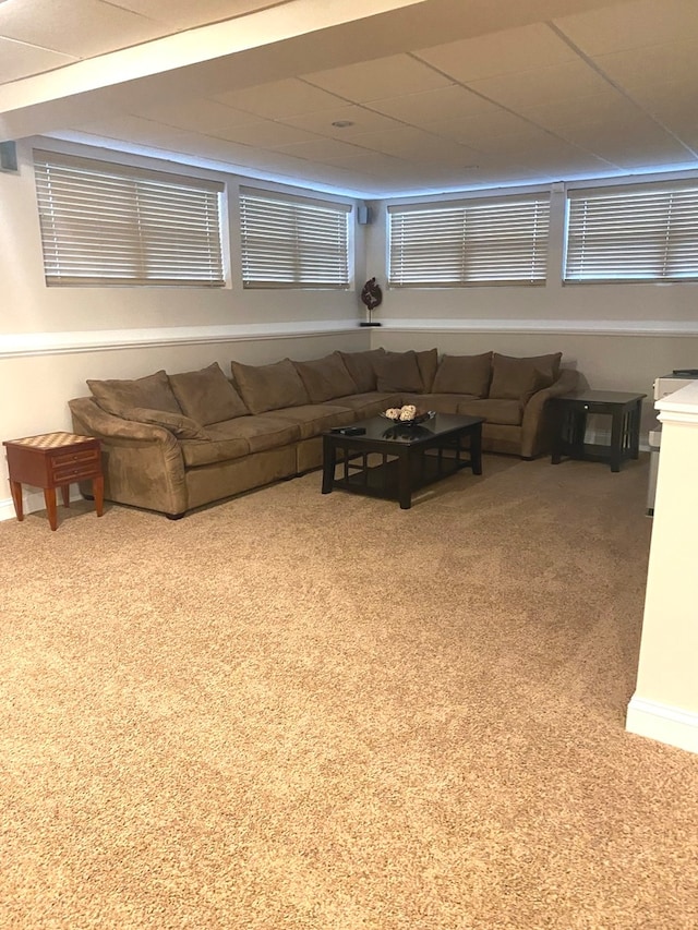 unfurnished living room with carpet flooring and a paneled ceiling