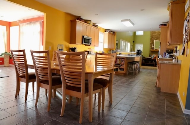 dining space featuring dark tile patterned flooring