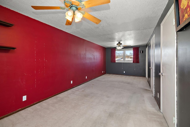 spare room with light colored carpet and a textured ceiling