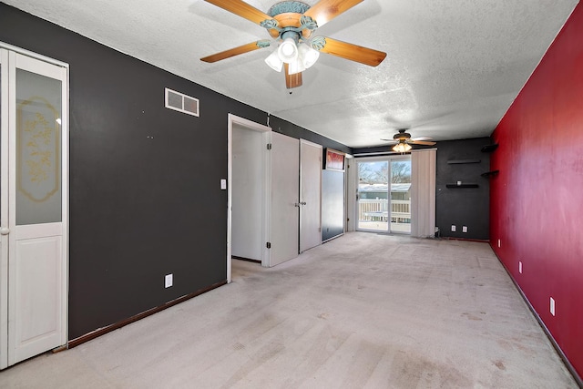 unfurnished room with ceiling fan, light colored carpet, and a textured ceiling