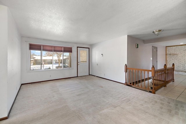 carpeted empty room with a textured ceiling