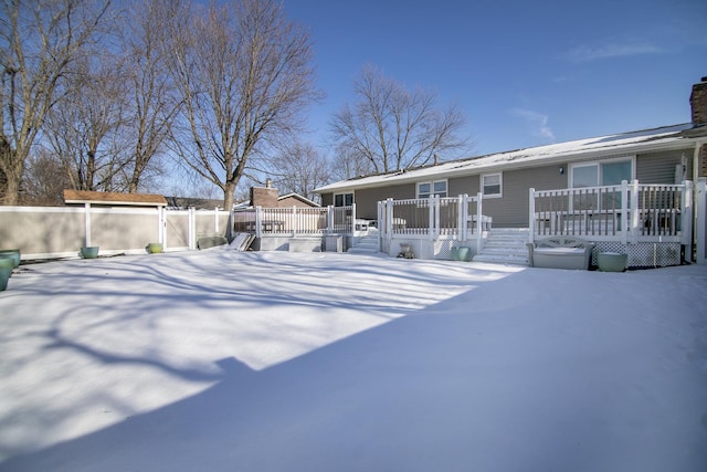 snow covered house featuring a wooden deck