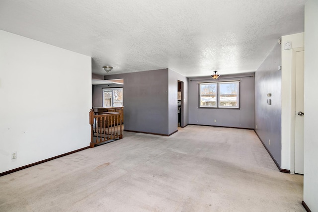 unfurnished room featuring light carpet and a textured ceiling