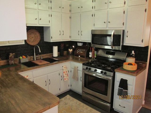 kitchen featuring sink, white cabinetry, stainless steel appliances, and tasteful backsplash