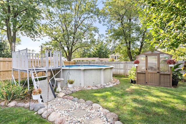 view of yard with a fenced in pool and an outdoor structure