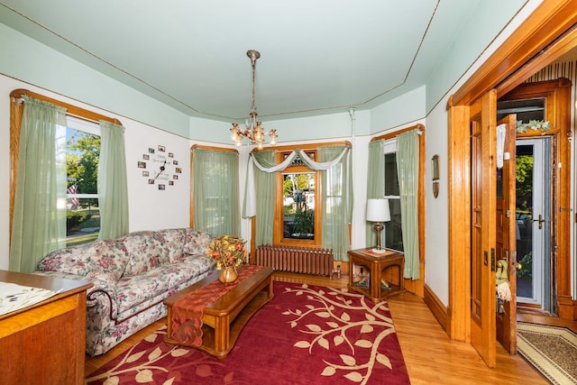 sitting room with radiator, light hardwood / wood-style floors, and a notable chandelier